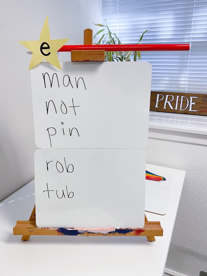 A Magic e wand balanced on top of a white board with the words man, not, pin, rob, and tub written on it.